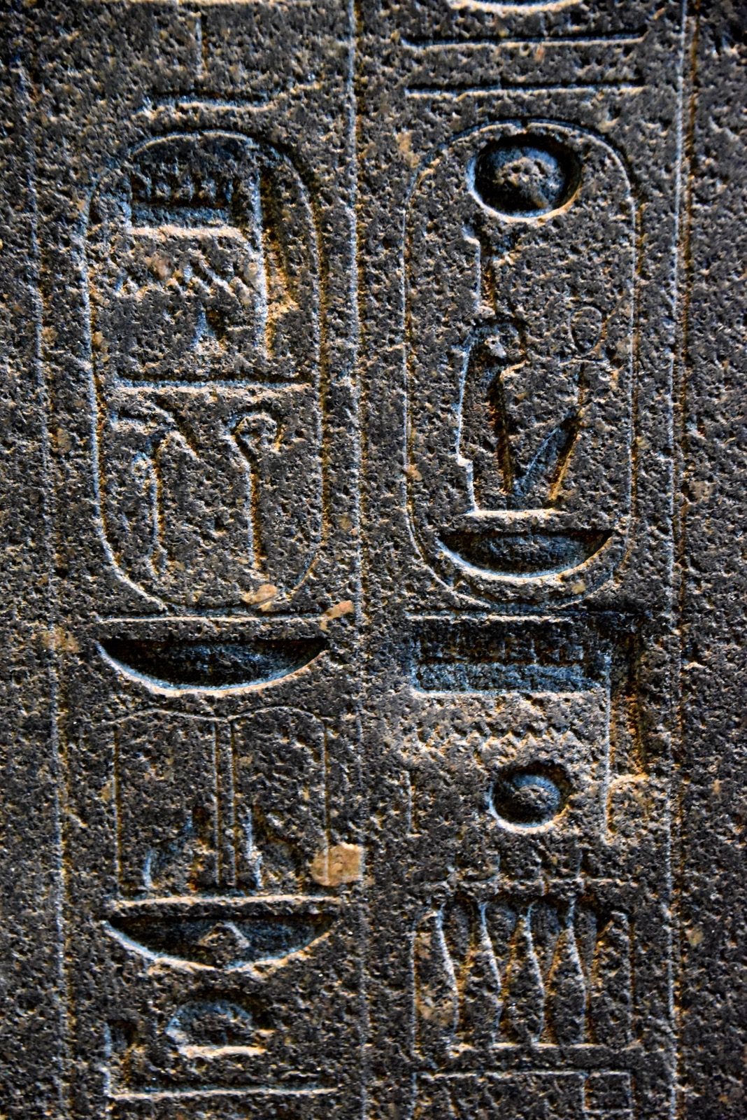 Hieroglyphs on the back pillar of a statue of Amenhotep III, showing two places where Akhenaten's agents chiseled out the name of the god Amun, later re-carved on a deeper surface after Akhenaten's death.