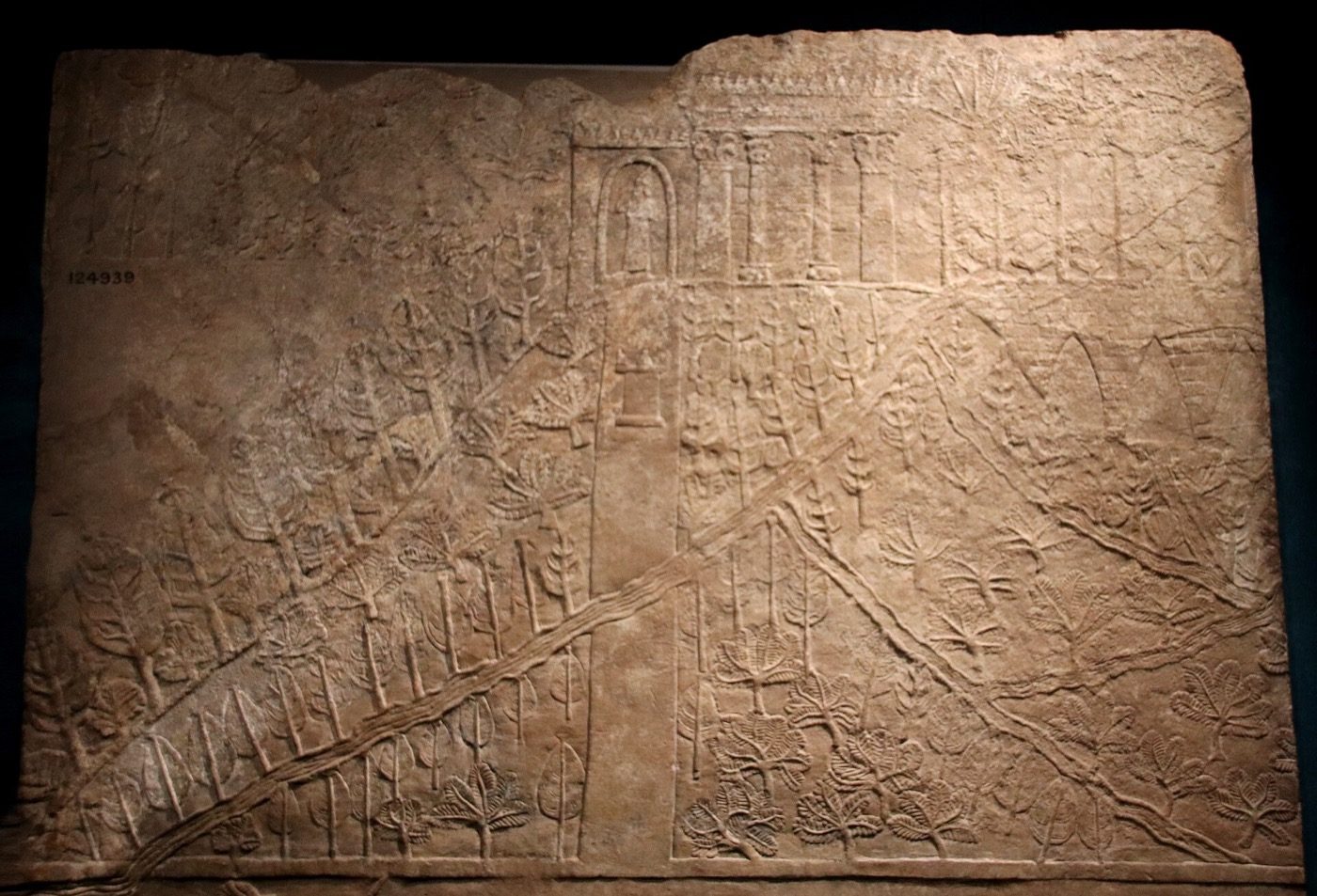 Gypsum wall relief from the North Palace at Nineveh, about 645-635 BC, carved with a hillside of trees threaded by a raised watercourse and a pillared building on the crest. This is a contemporary Assyrian carving of a real garden at Nineveh; no comparable image of a garden at Babylon has ever been found.