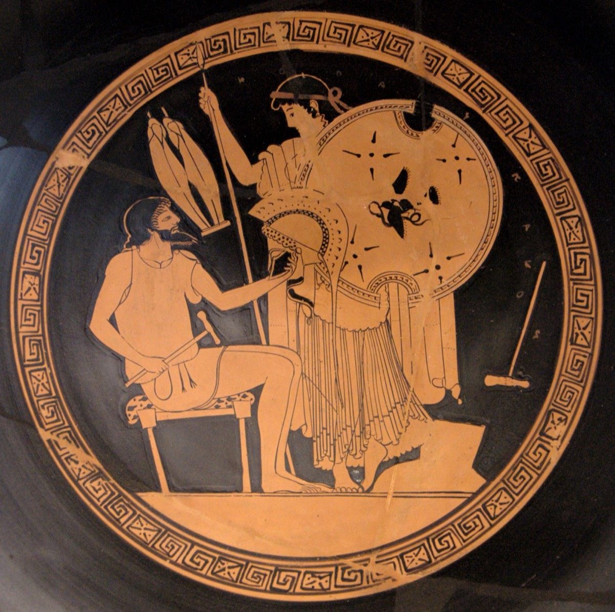Attic red-figure kylix by the Foundry Painter, circa 490-480 BC, showing Hephaestus handing the newly forged armor of Achilles to Thetis, with the god's tongs and hammer visible at his workbench.