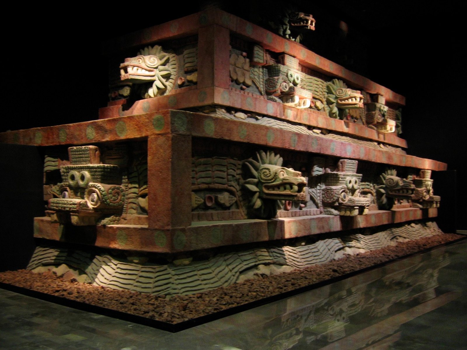 A reconstructed section of the facade of the Temple of the Feathered Serpent from Teotihuacan, showing a carved feathered serpent head, on display at the National Museum of Anthropology in Mexico City.